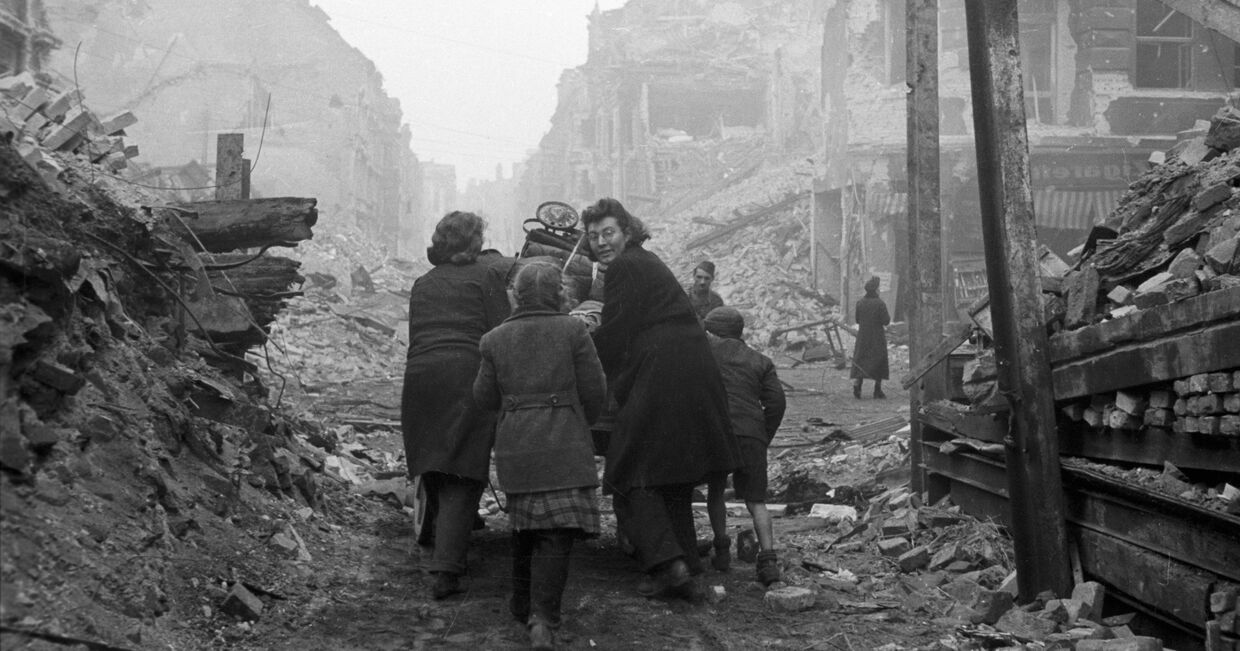 Жители Берлина возвращаются домой по заваленной обломками улице. Бои закончились.