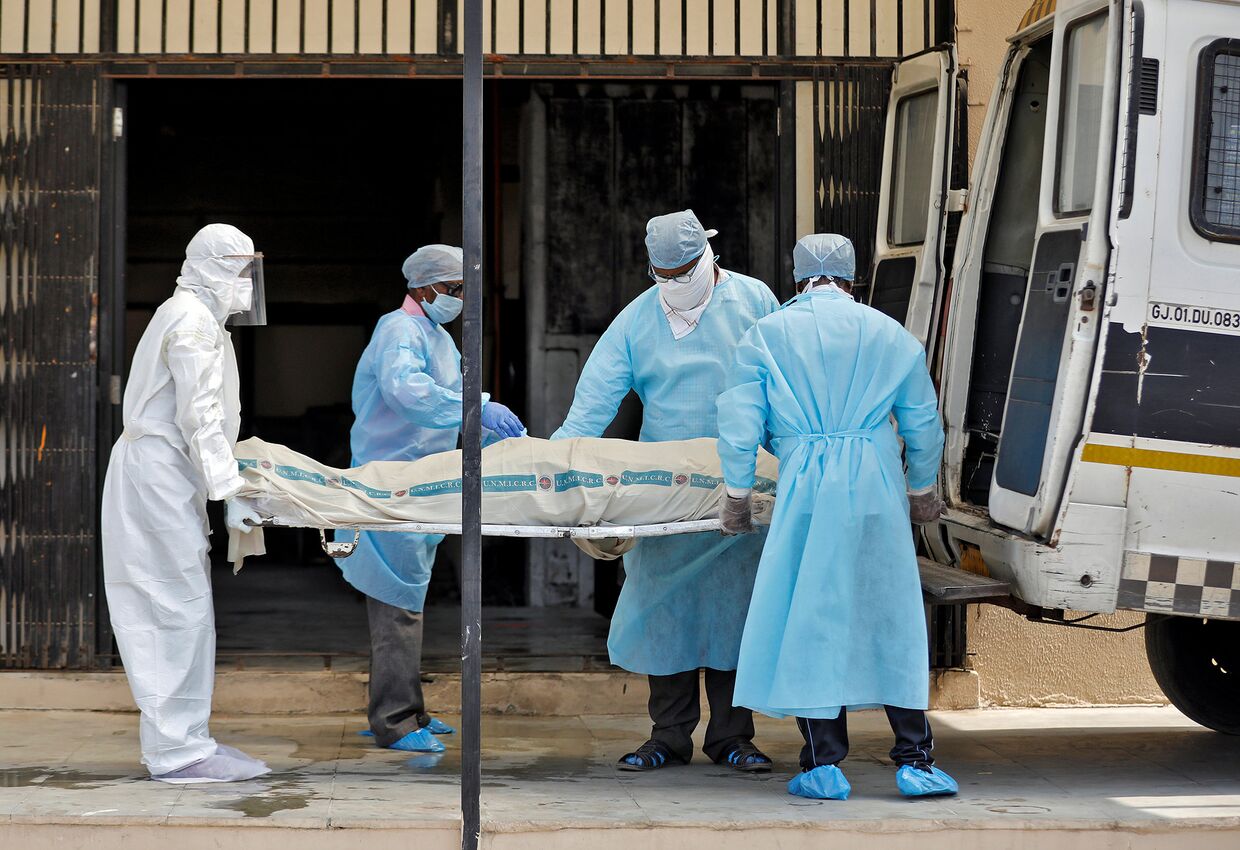 Медики выносят тело пациента, умершего от коронавируса в Ахмадабаде, Индия