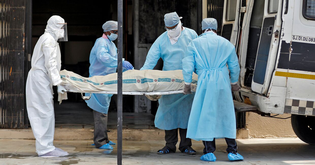 Медики выносят тело пациента, умершего от коронавируса в Ахмадабаде, Индия