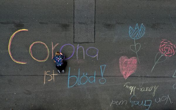 Девочка пишет на асфальте тупая корона в Дортмунде, Германия