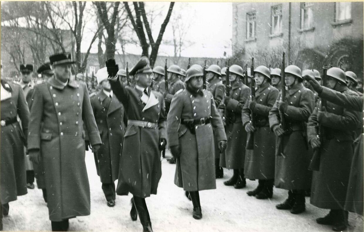Видкун Квислинг (слева) и рейхскомиссар Йозеф Тербовен инспектируют строй полицейских офицеров в 1942 году