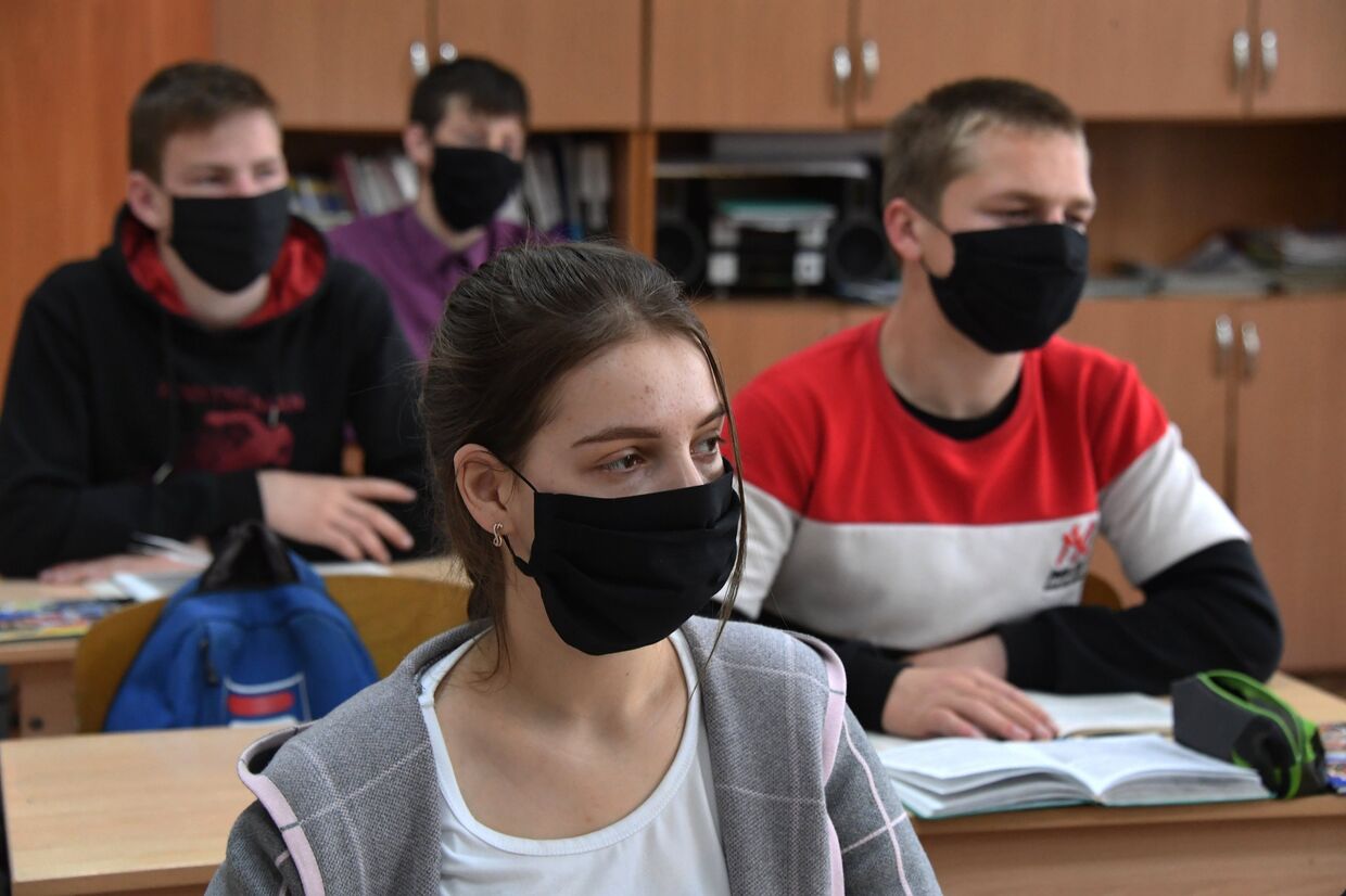Ученики в защитных масках на уроке в школе