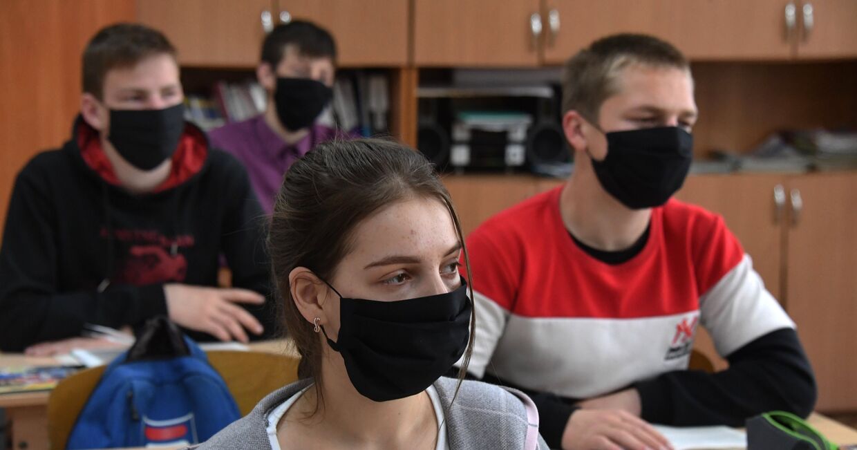 Ученики в защитных масках на уроке в школе