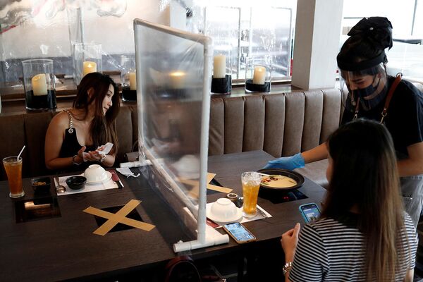 Посетители обедают во вновь открывшемся ресторане в Бангкоке