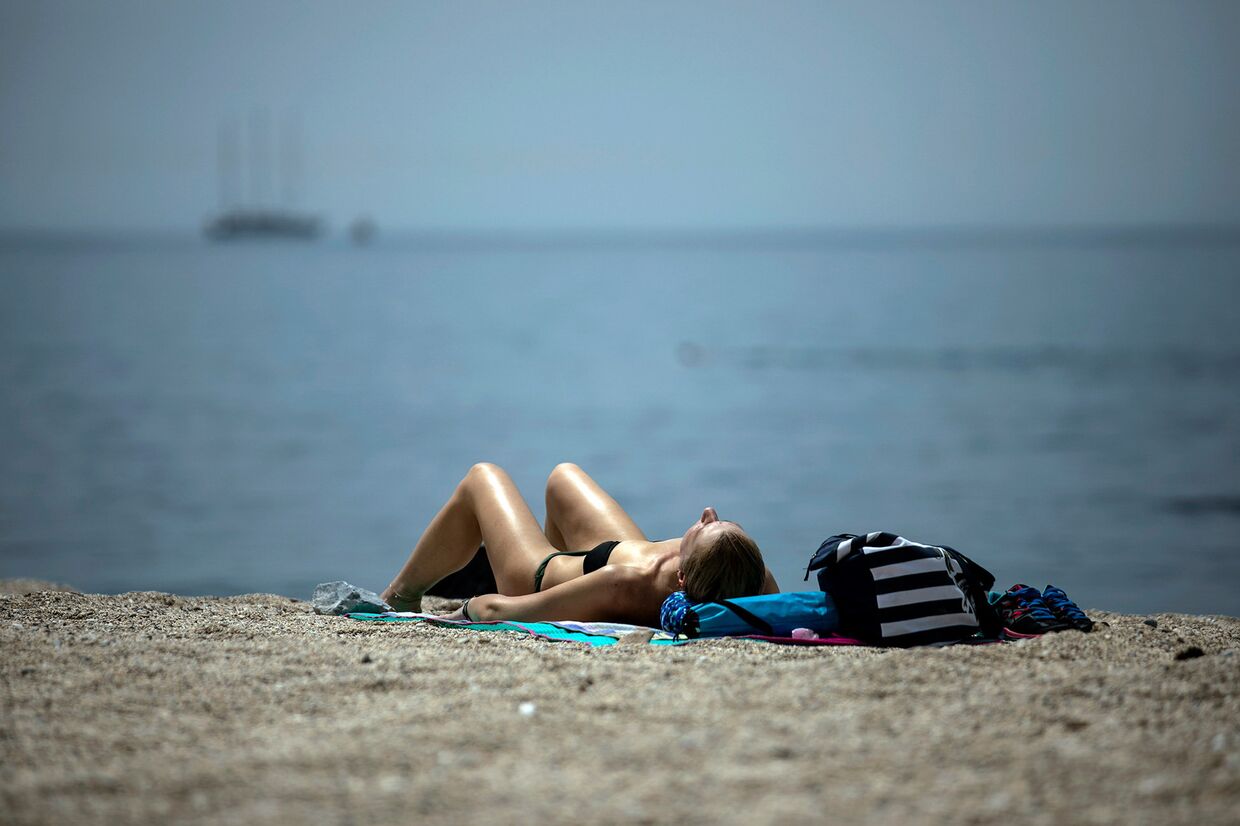 Женщина на пляже недалеко от Афин, Греция