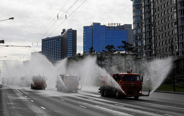 Автомобили коммунальных служб во время дезинфекции дорог и общественных пространств в Москве