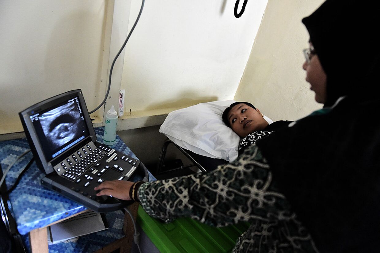 Врач делает УЗИ беременной женщине в медицинской клинике в Шукадане, Индонезия