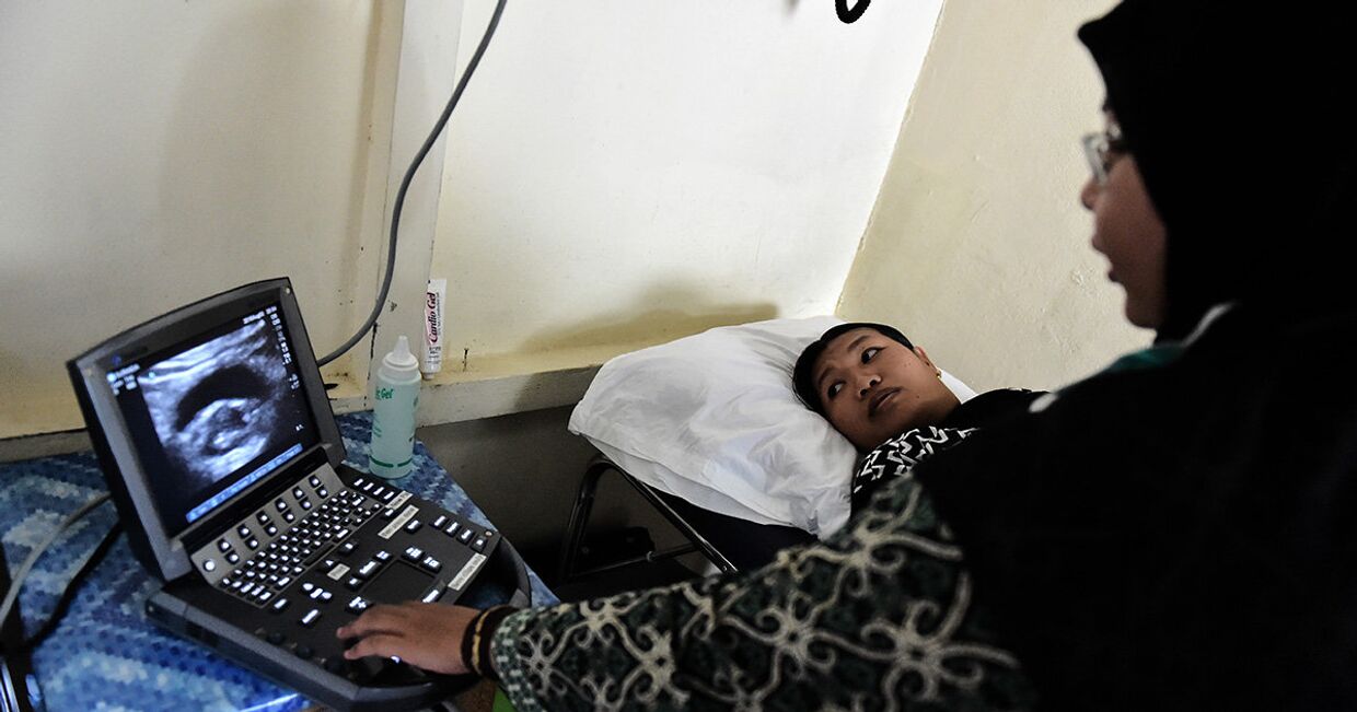 Врач делает УЗИ беременной женщине в медицинской клинике в Шукадане, Индонезия