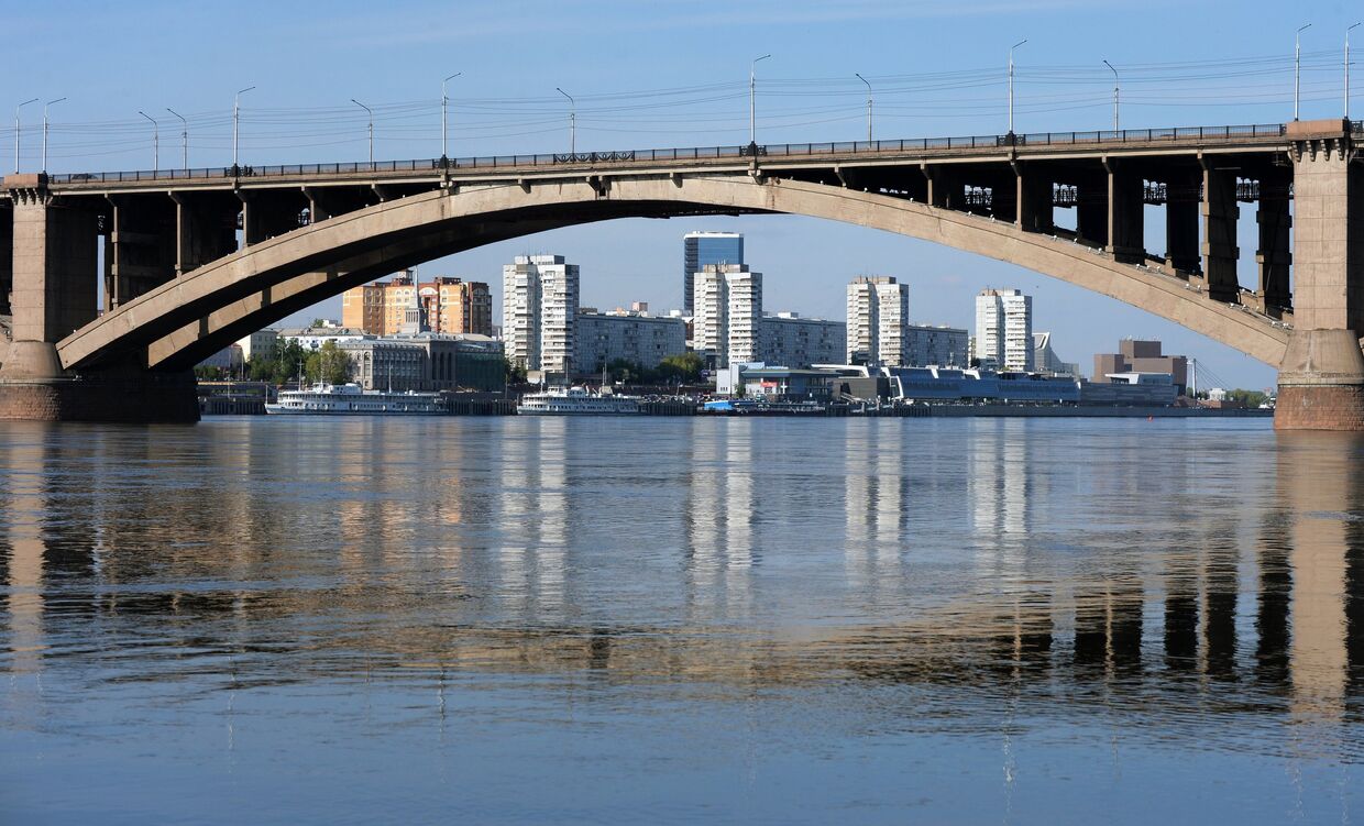 Вид на левобережную набережную и Коммунальный мост с острова Отдыха на реке Енисей в Красноярске