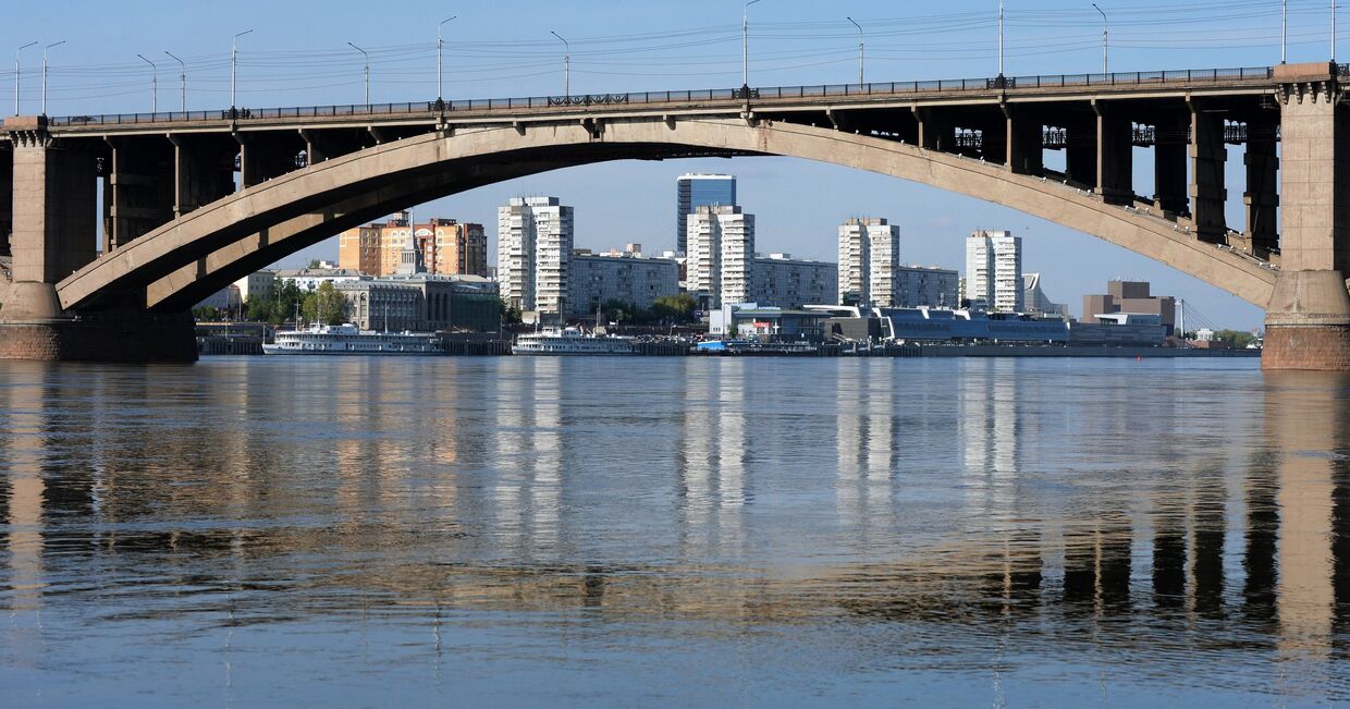 Вид на левобережную набережную и Коммунальный мост с острова Отдыха на реке Енисей в Красноярске