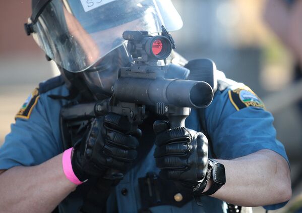 Сотрудник полиции стреляет слезоточивым газом в протестующих в Сент-Поле, штат Миннесота