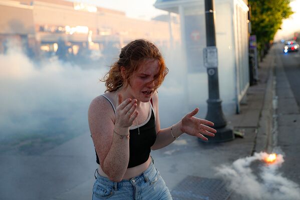 Участница протестов в облаке слезоточивого газа в Сент-Поле, штат Миннесота