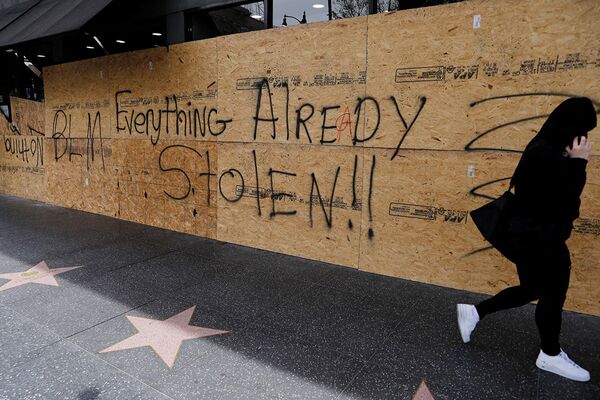 Надпись «все уже украдено» на закрытой фанерой витрине магазина в Лос-Анджелесе