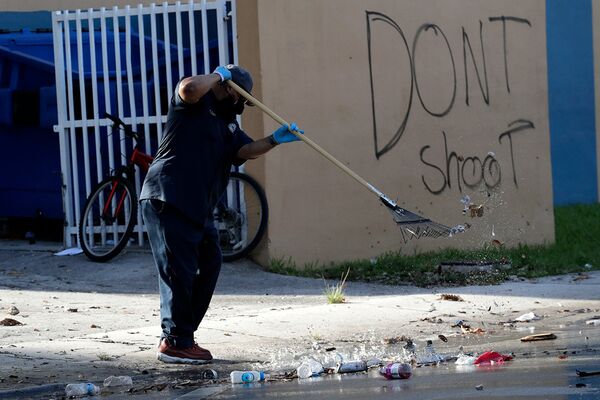 Мужчина убирает улицу рядом в граффити «Не стреляйте» в Майами