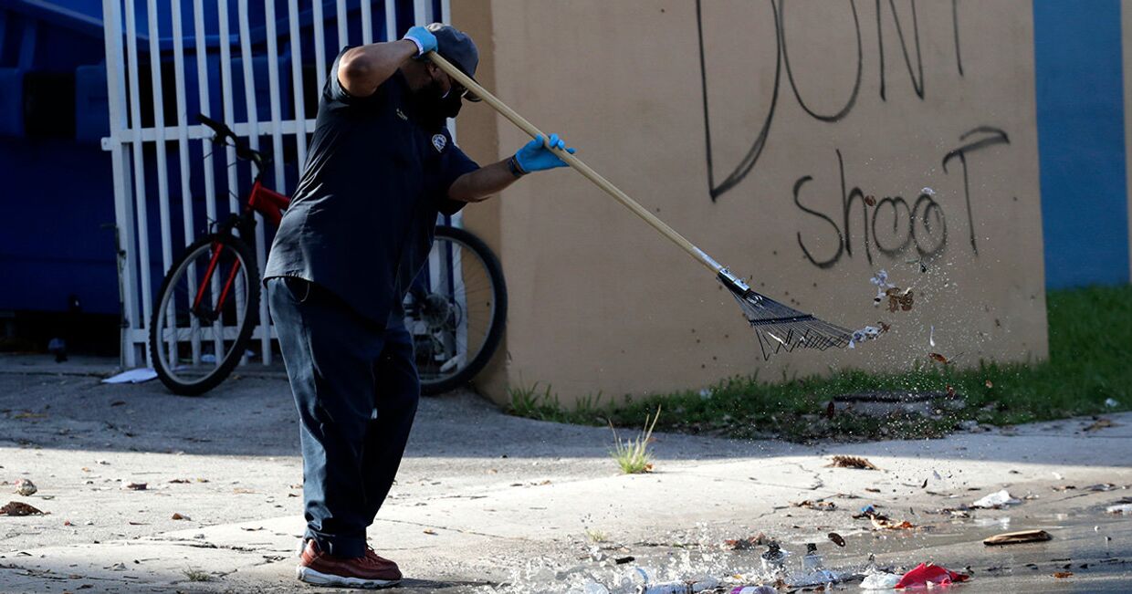 Мужчина убирает улицу рядом в граффити «Не стреляйте» в Майами
