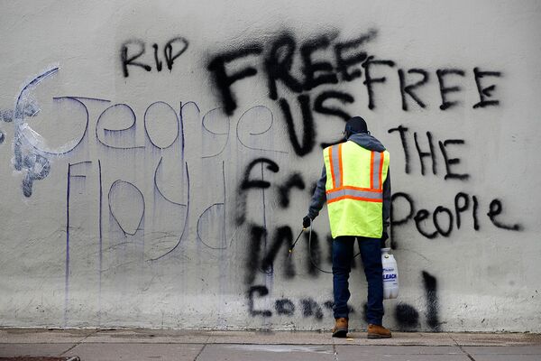 Рабочий смывает граффити в Вашингтоне