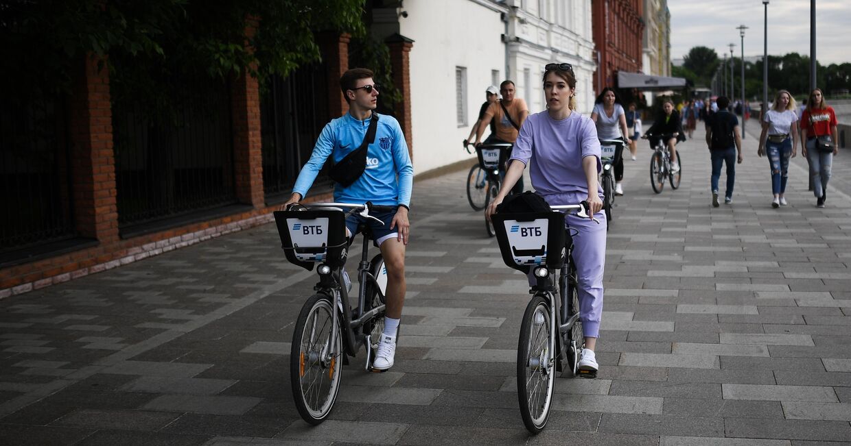 Люди катаются на велосипедах по Берсеневской набережной в Москве