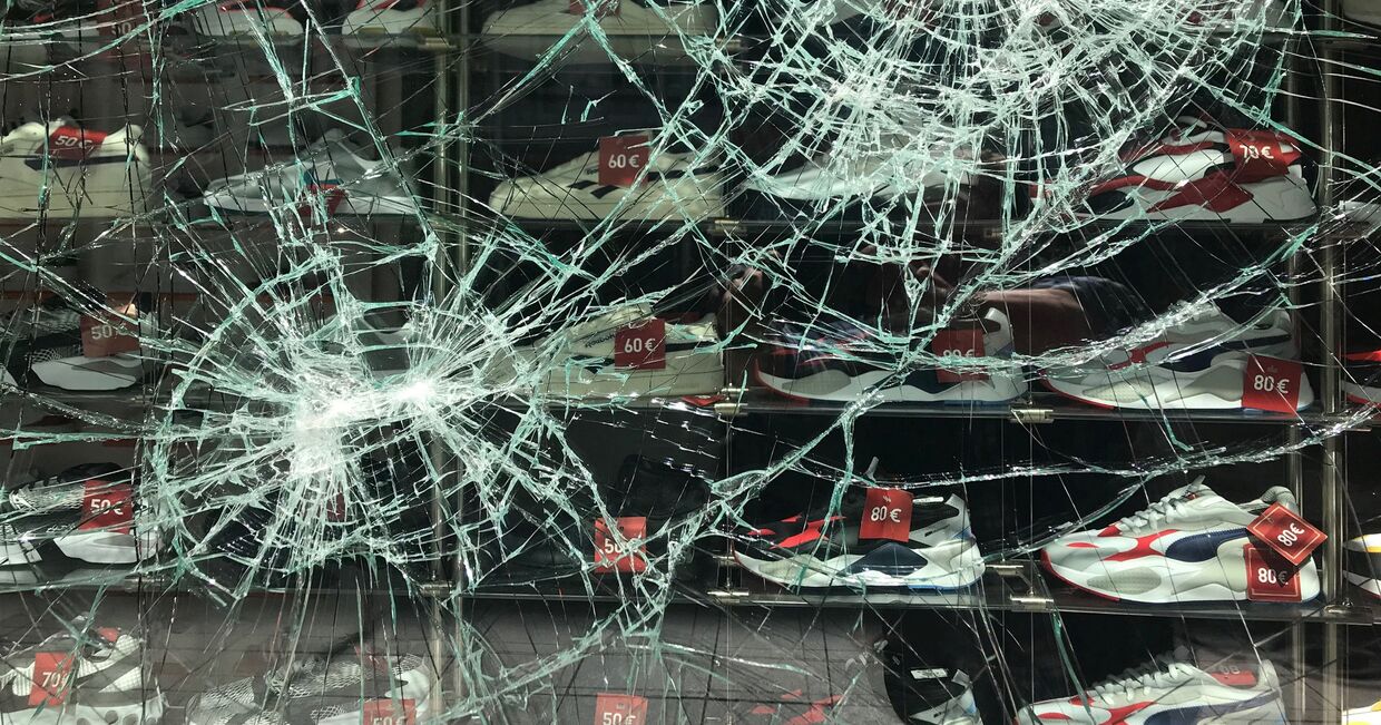 Разбитая в ходе беспорядков витрина магазина в центре Штутгарта, Германия