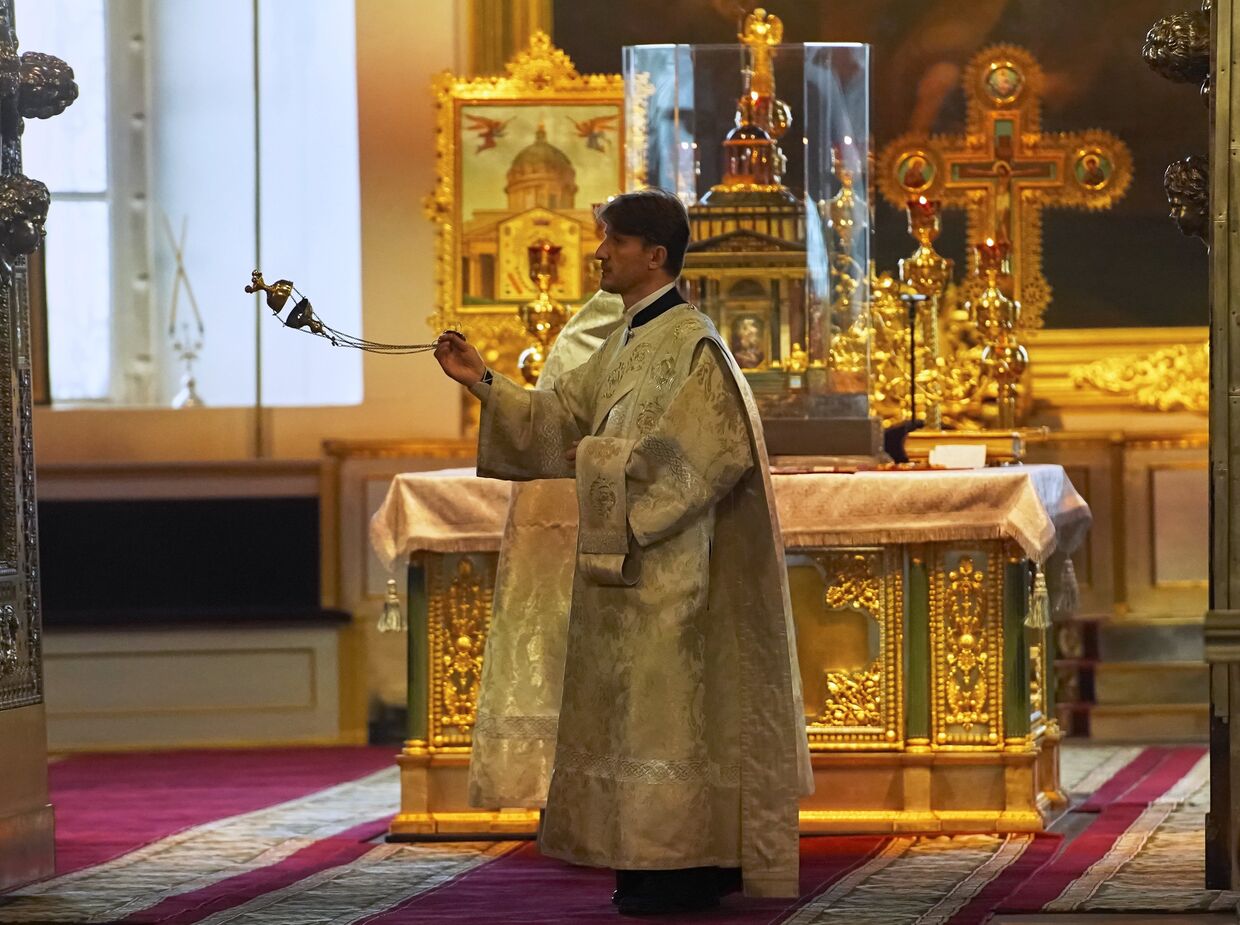 Священнослужитель во время богослужения в Казанском кафедральном соборе в Санкт-Петербурге, открывшемся после карантина
