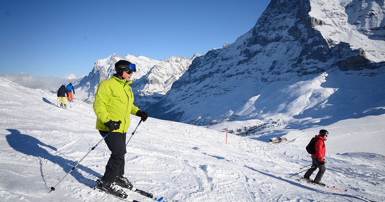 Туристы катаются на лыжах в Кляйне-Шейдегге, Гриндельвальд, Швейцария