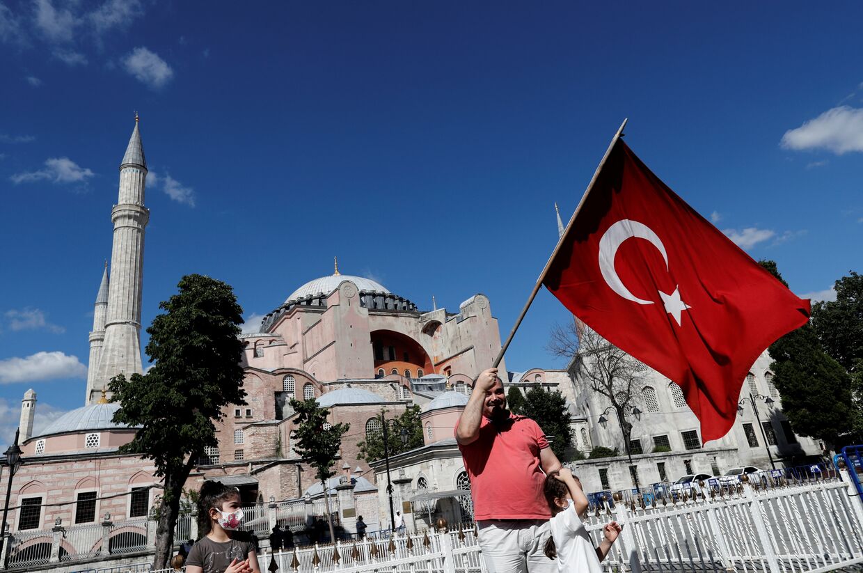 10 июля 2020. Мужчина с флагом Турции рядом с Собором Святой Софии в Стамбуле