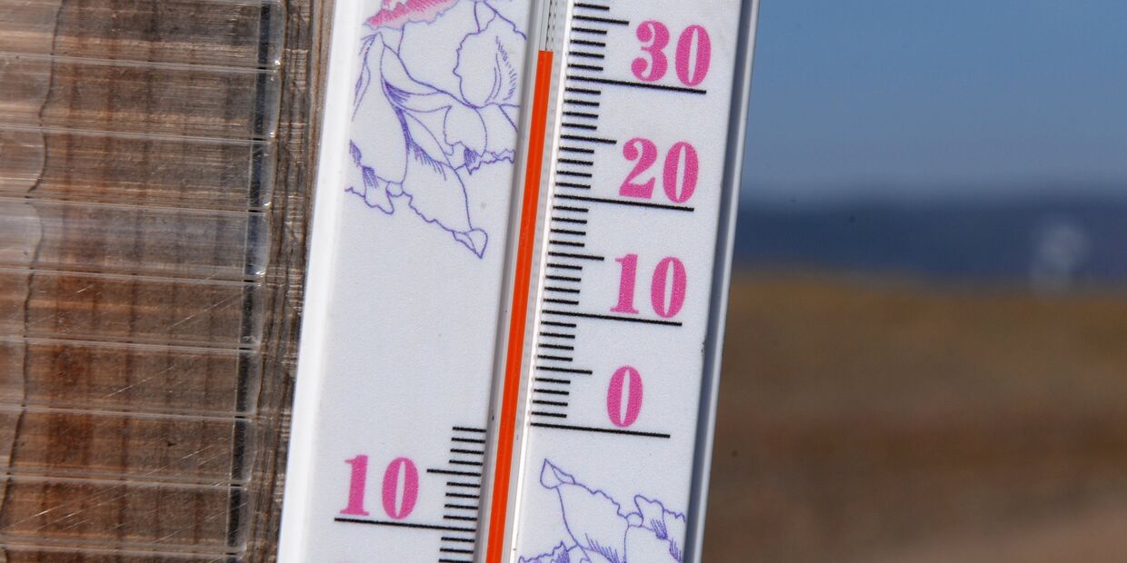 +32 градуса Цельсия на солнце показывает термометр на стене зимнего передвижного рыбацкого домика на берегу реки Енисей в окрестностях Красноярска