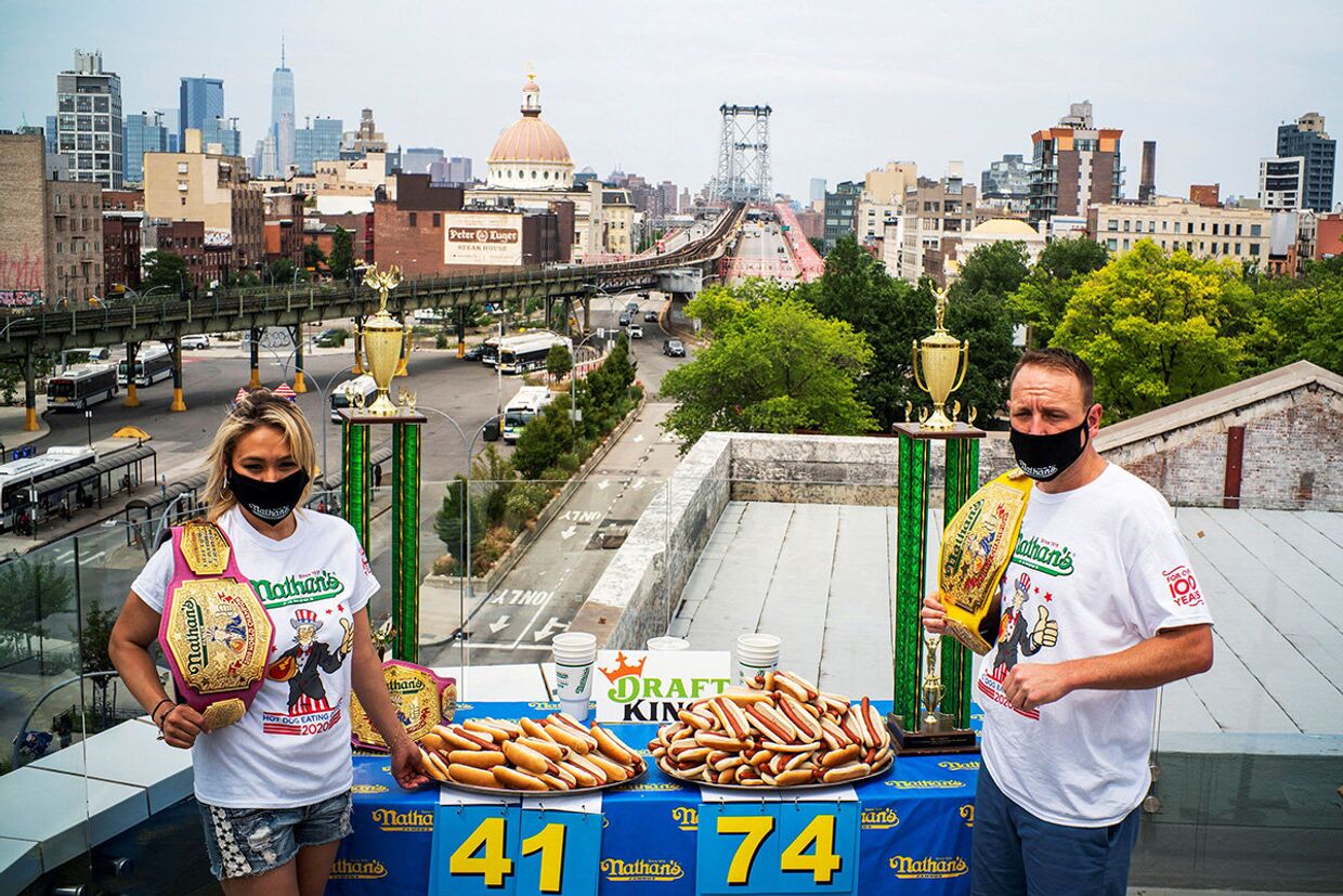 Рекордсмен мира среди мужчин Джои Честнат и рекордсмен среди женщин Мики Судо во время официальной церемонии взвешивания для конкурса по поеданию хот-догов в Нью-Йорке