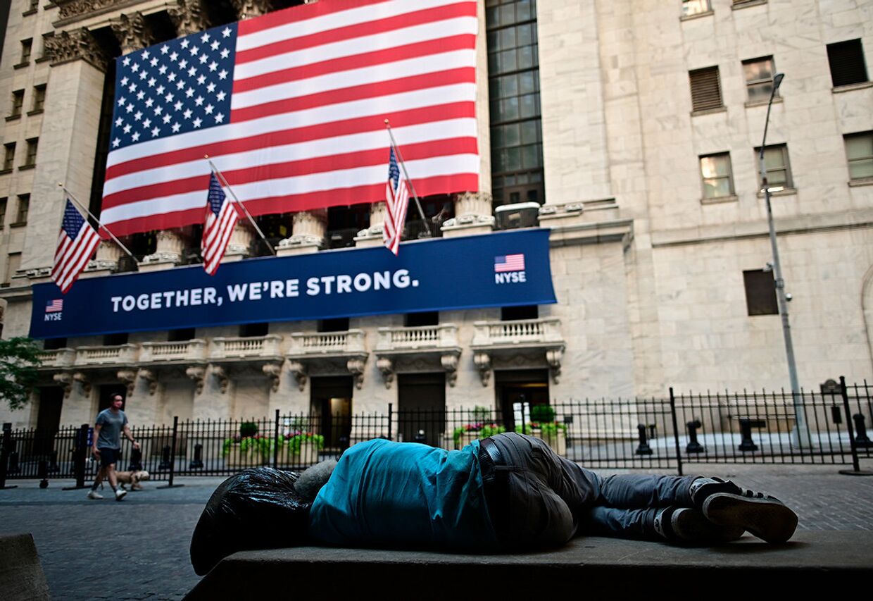 Мужчина спит на скамейке возле Нью-Йоркской фондовой биржи