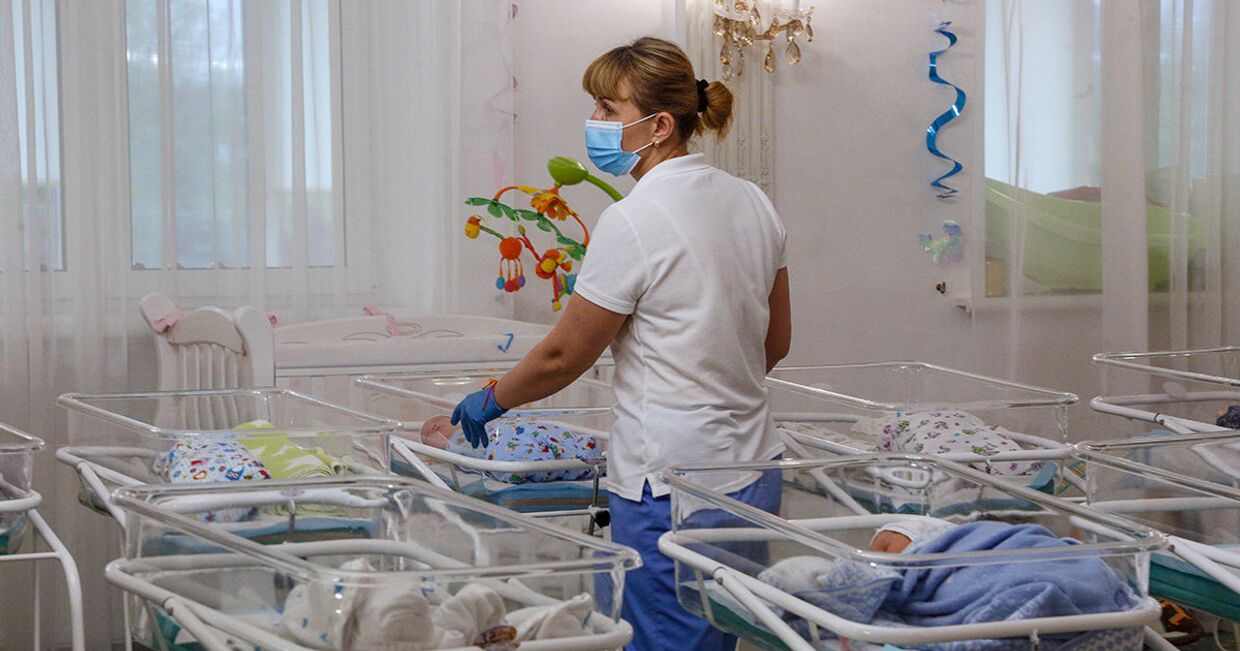 Медсестра в заботится о младенцах, рожденных суррогатными матерями в Киеве