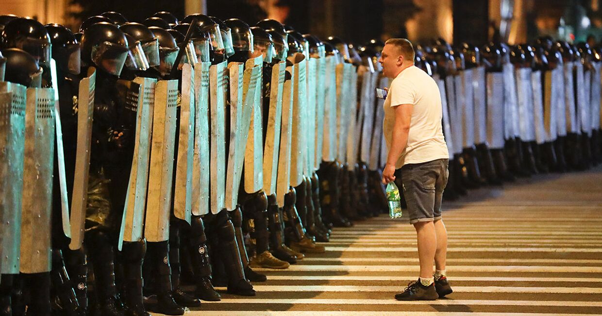 Протестующий говорит с полицией во время митинга в Минске