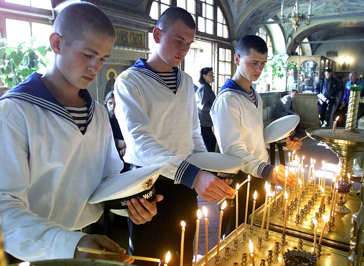 23 августа 2000. Российские моряки ставят свечи в память о погибших членах экипажа подводной лодки «Курск»