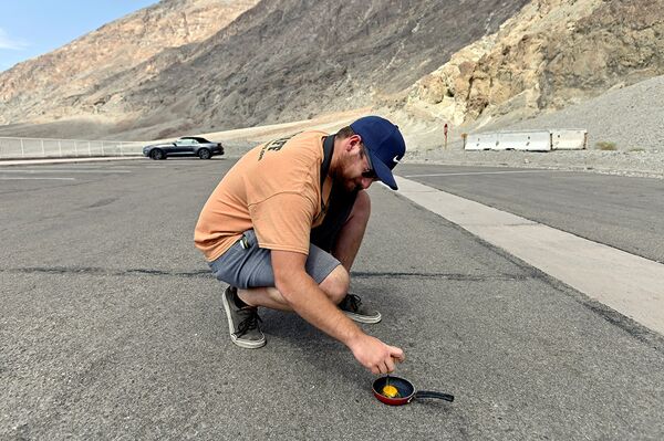 Мужчина пытается пожарить яйцо в Национальном парке Долины Смерти
