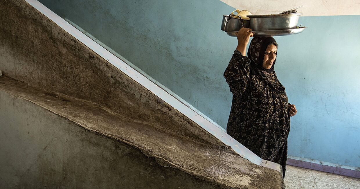 Женщина с горшками в школе в в городе Хасака, Турция