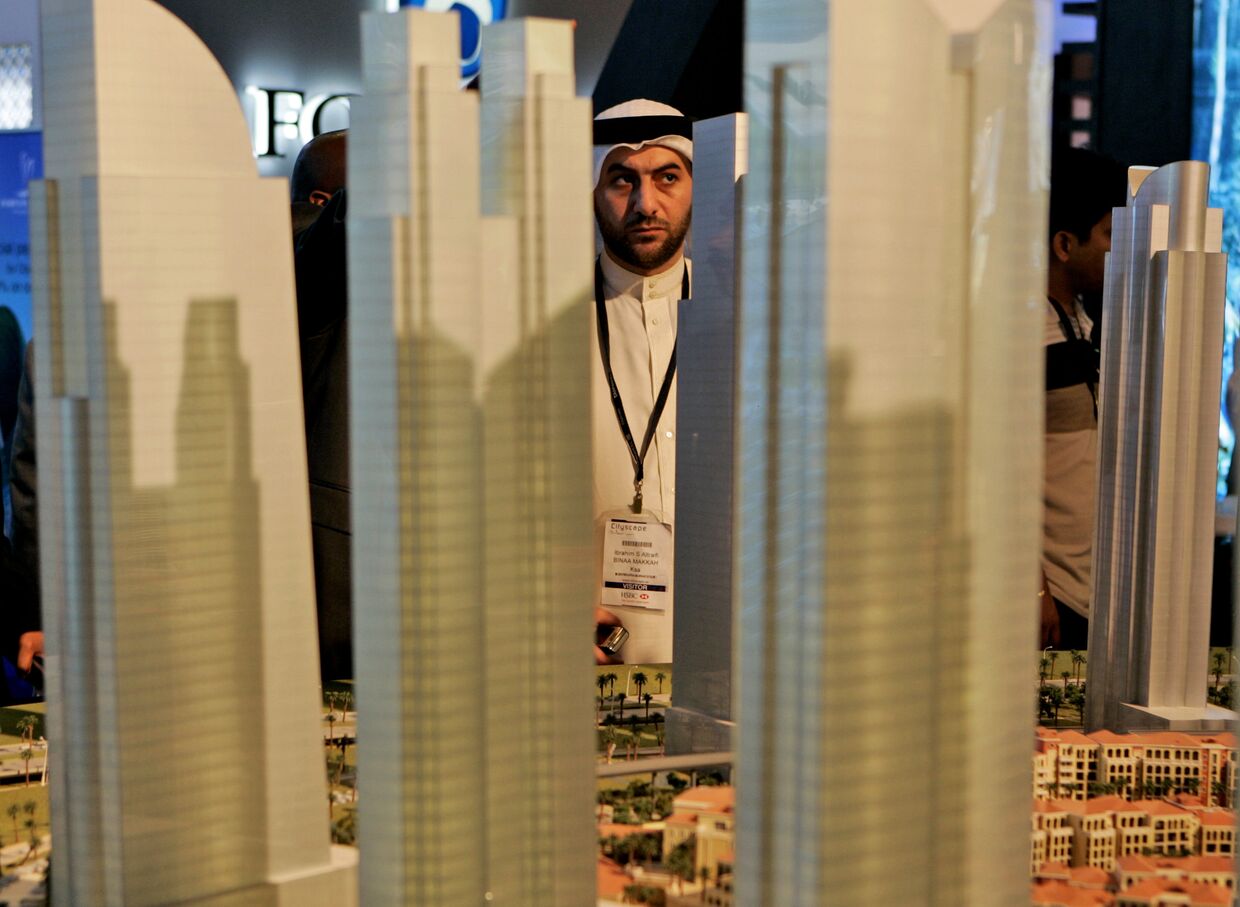 Араб рассматривает макет строительного проекта в финансовом районе Дубая, ОАЭ