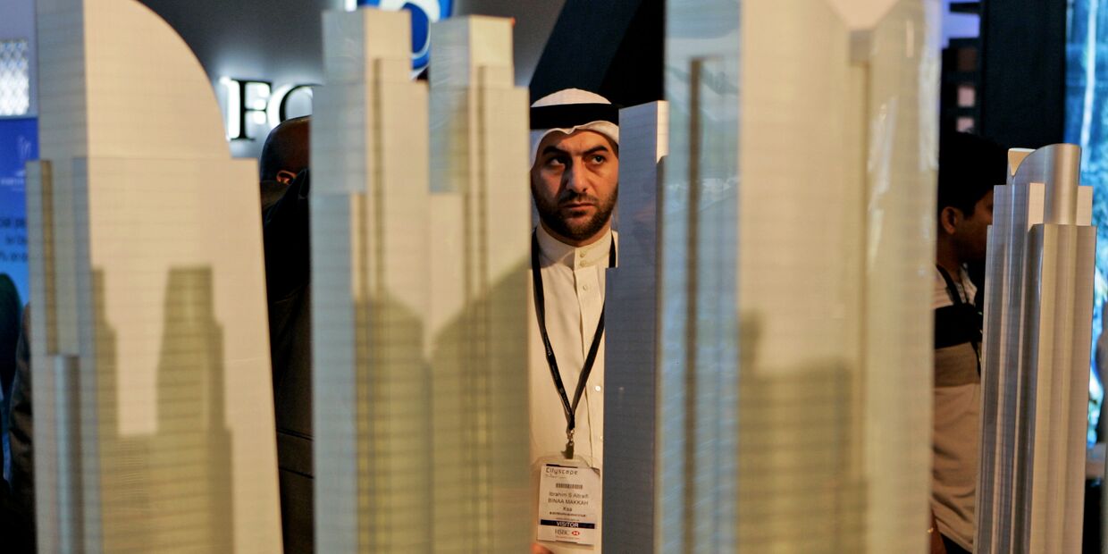 Араб рассматривает макет строительного проекта в финансовом районе Дубая, ОАЭ