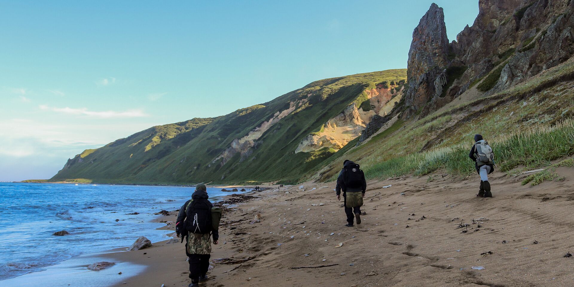 Участники экспедиции идут по берегу бухты Тетяева острова Уруп (остров южной группы Большой гряды Курильских островов). Участники экспедиции идут по берегу бухты Тетяева острова Уруп (остров южной группы Большой гряды Курильских островов). - ИноСМИ, 1920, 20.10.2020