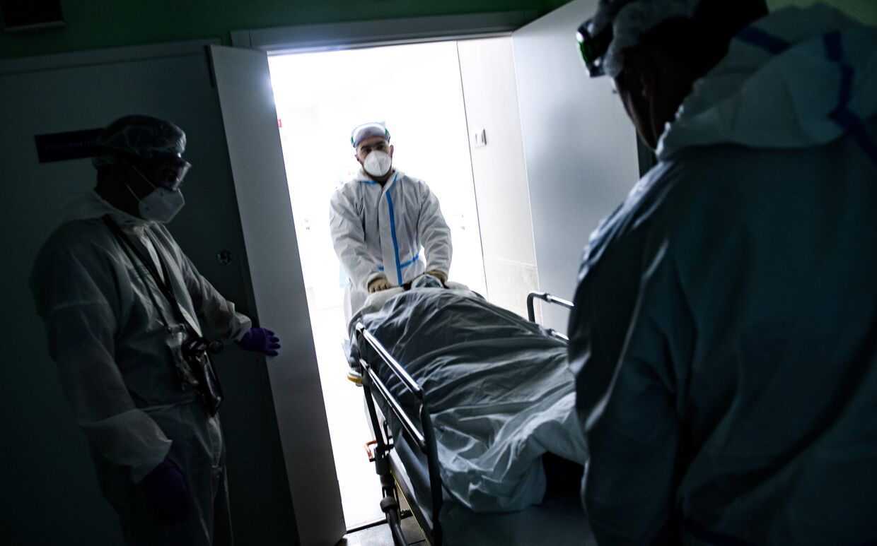 Медицинские работники оказывают помощь пациенту с COVID-19 в отделении компьютерной томографии