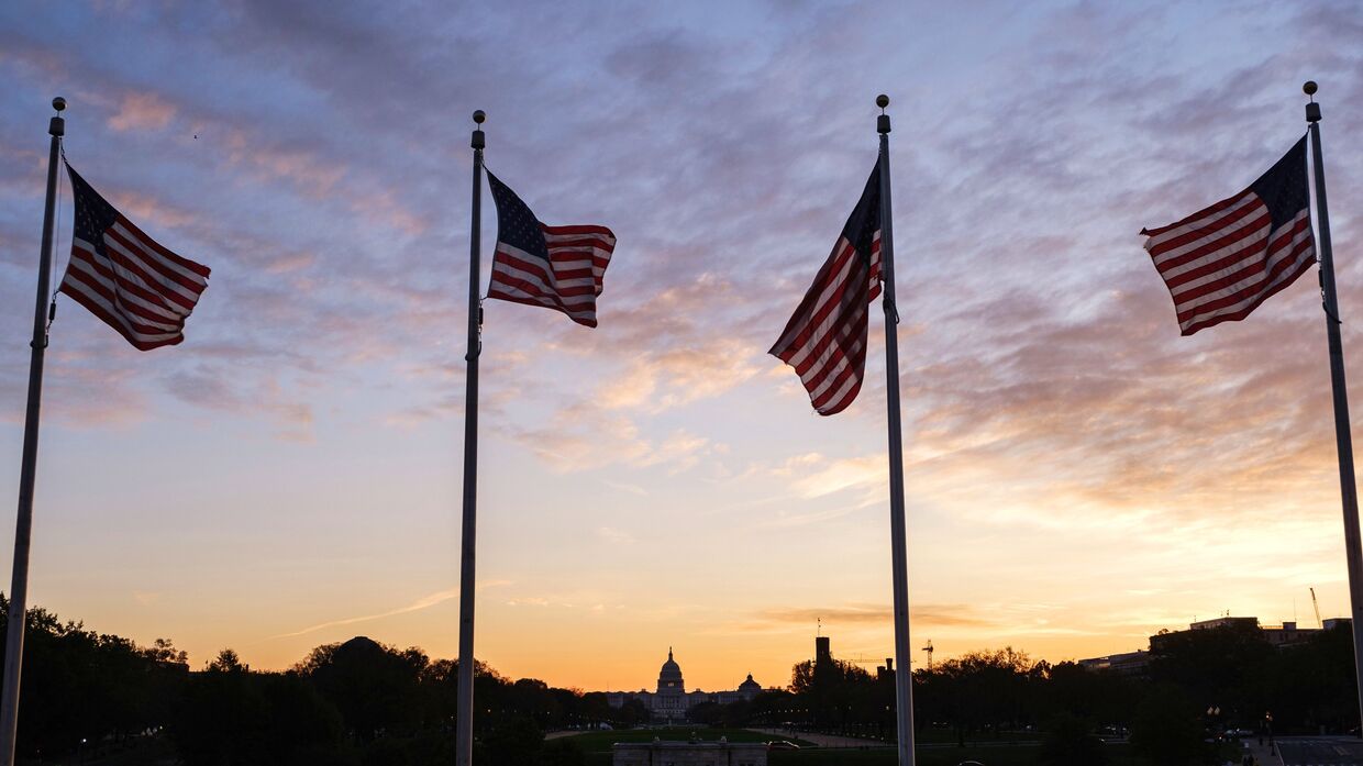 Флаги США около монумента первому президенту США Джорджу Вашингтону в Вашингтоне