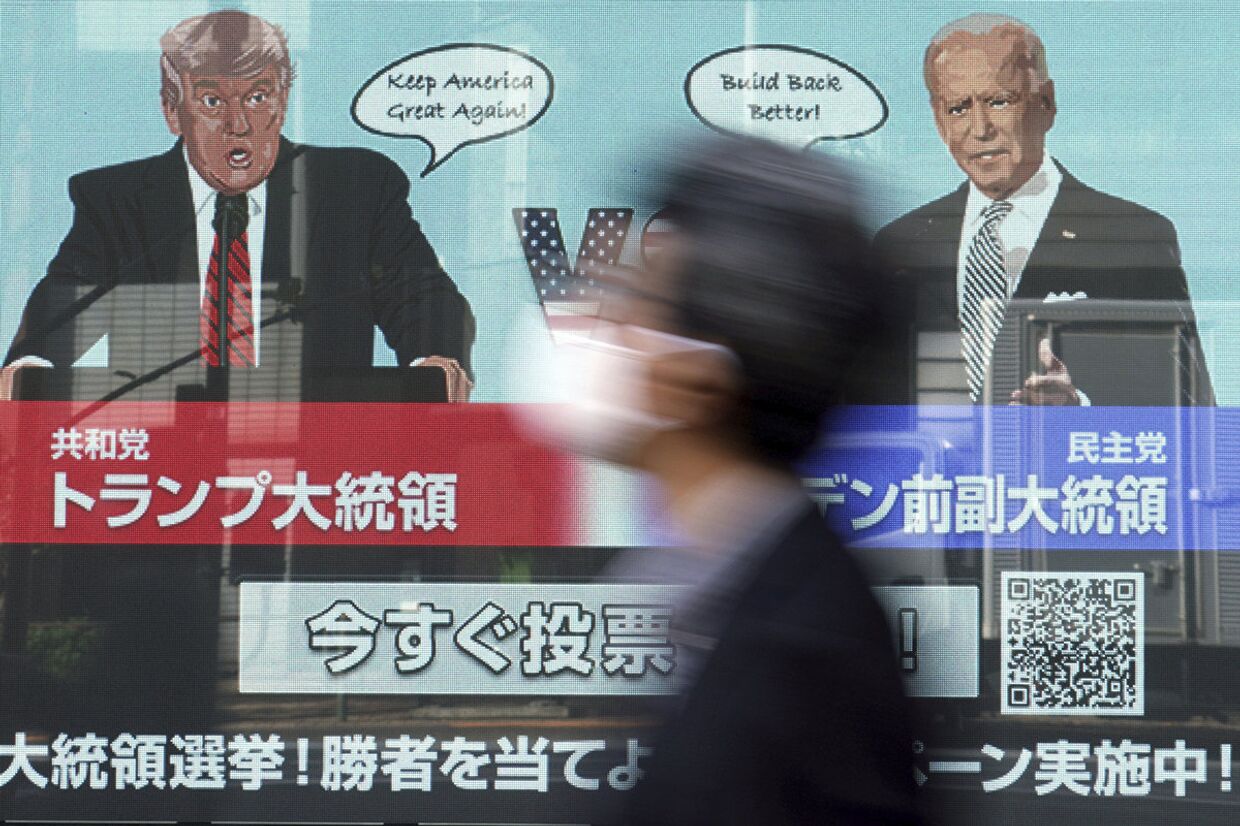 Дональд Трамп и Джо Байден на экране в Токио
