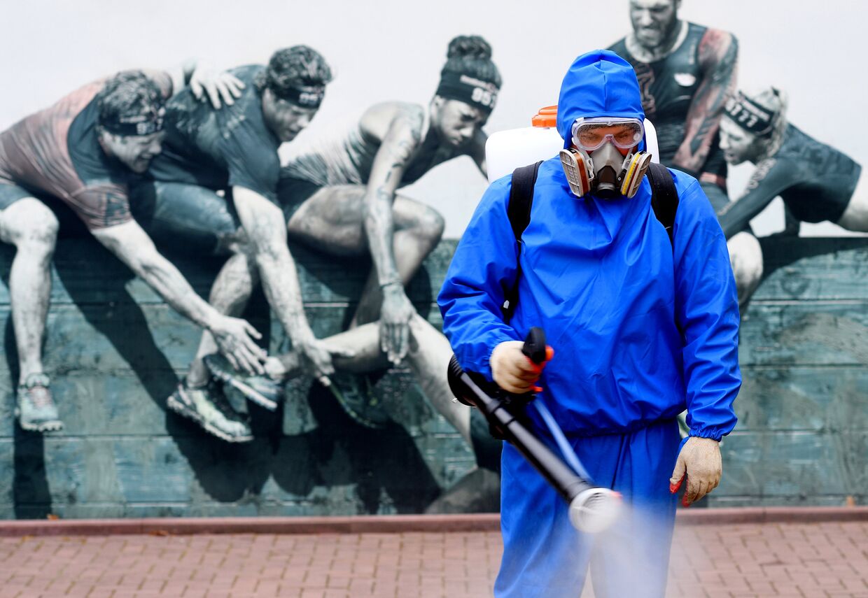 Сотрудник санитарной службы проводит дезинфекцию в Парке Победы в Москве