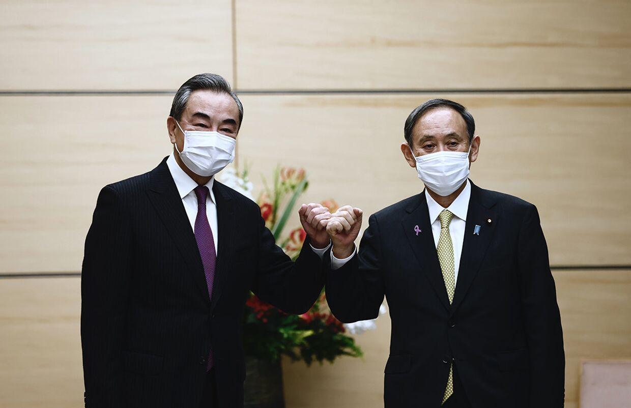 Премьер-министр Японии Ёсихидэ Суга и министр иностранных дел Китая Ван И на встречи в Токио