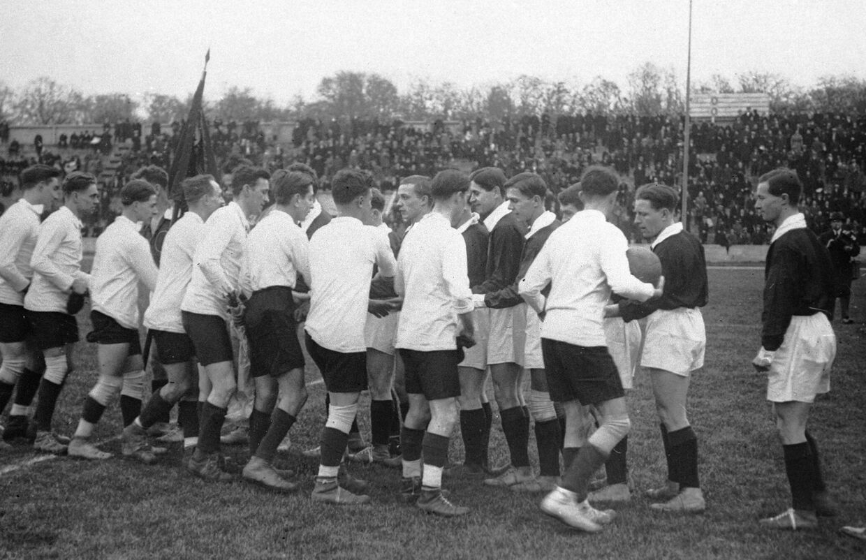 Футболисты сборных рабочих команд Советского Союза и Франции обмениваются рукопожатиями перед началом матча на стадионе Першинг