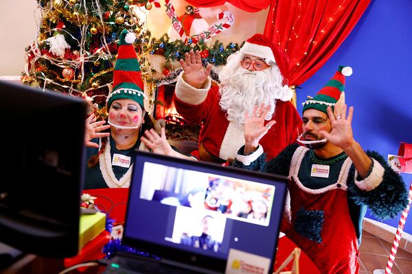 Санта-Клаус и его помощники эльфы общаются с детьми через веб-камеру в Риме