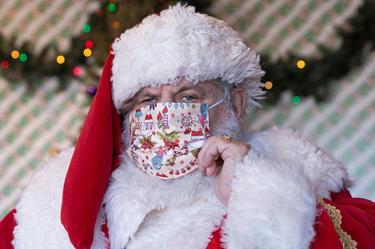 Санта-Клаус поправляет маску в торговом центре в Нью-Йорке
