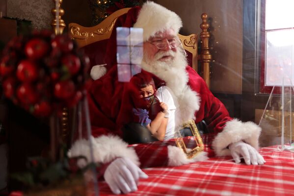 Санта-Клаус за защитным стеклом в торговом центре в Коммерсе, Калифорния