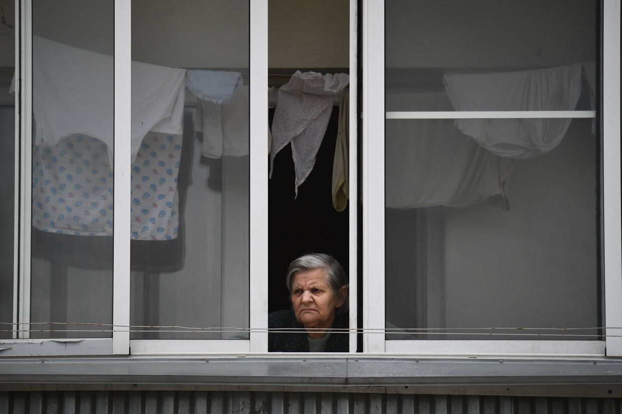 Женщина на балконе жилого дома