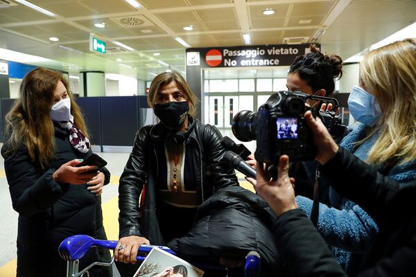 Представители СМИ беседуют с пассажирами из Великобритании в аэропорту Фьюмичино