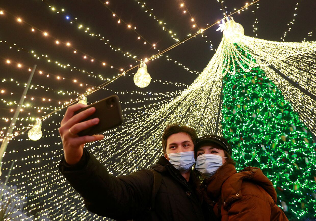 Пара делает селфи перед рождественской елкой в центре Киева