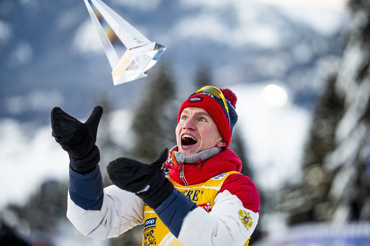 Александр Большунов (Россия), занявший первое место в общем зачете на соревнованиях по лыжным гонкам «Тур де Ски» среди мужчин в итальянском Валь-ди-Фьемме, на церемонии награждения