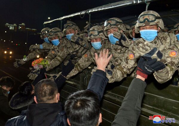 Жители приветствуют военных в честь VIII съезда Трудовой партии в Пхеньяне